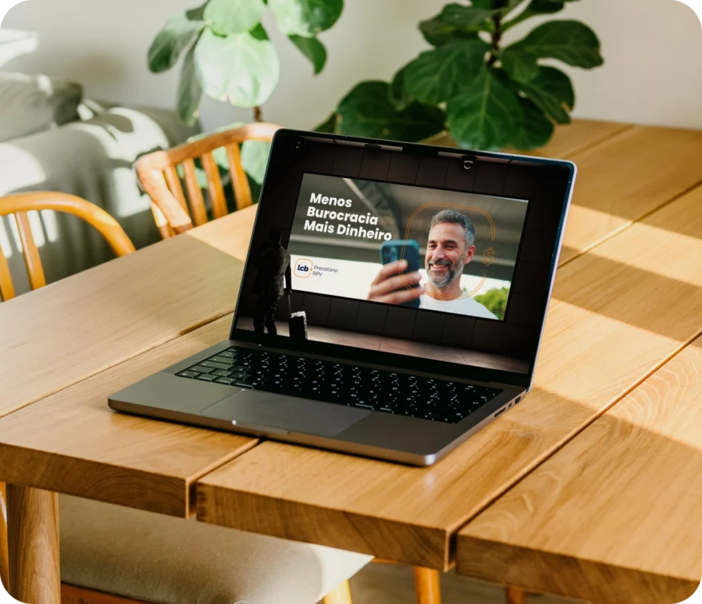 Laptop aberto exibindo vídeo sobre "Menos Burocracia, Mais Dinheiro" da LCbank